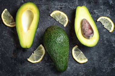 avokado ve koyu siyah bir zemin üzerine limon
