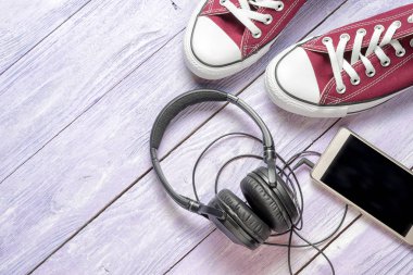 lastikbotlar, cep telefonu ve ahşap arka plan, üstten görünüm, kulaklıktan alanı Kopyala