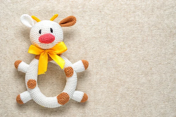 Mucca giocattolo amigurumi su uno sfondo lavorato a maglia con spazio copia — Foto Stock