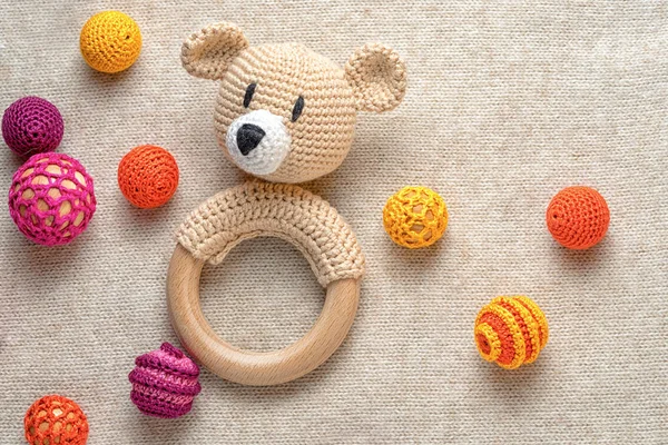 Amigurumi toy bear and crocheted beads on a knitted background with copy space — Stock Photo, Image