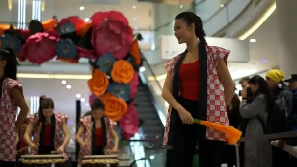 Moskou, Rusland - 5 maart 2017: groep van Japanse Taiko drummers meisjes uitvoert in "Oceanië" shopping center op het slaan bij de opening van een nieuwe Uniqlo unieke kleding magazijn. Danse met funs. — Stockvideo