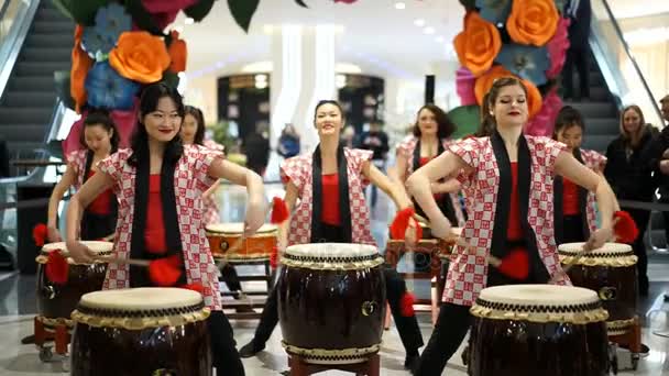 Moskou, Rusland - 5 maart 2017: groep van Japanse Taiko drummers meisjes uitvoert in "Oceanië" shopping center op het slaan bij de opening van een nieuwe Uniqlo unieke kleding magazijn. Rode drumsticks. — Stockvideo