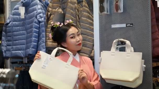 Moskow, Rusia - 5 Maret 2017: Geisha berbelanja di toko pakaian UNIQLO di antara barang-barang pakaian dan konsumen biasa. Kinerja diatur waktunya untuk pembukaan toko 15 baru di Rusia . — Stok Video