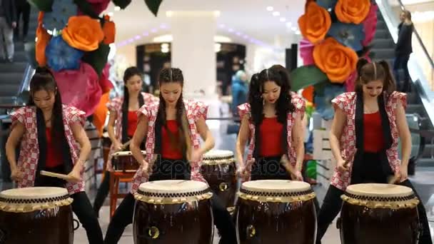 Moskou, Rusland - 4 maart 2017: groep van Japanse Taiko drummers meisjes uitvoert in "Oceanië" shopping center op het slaan bij de opening van een nieuwe Uniqlo unieke kleding magazijn. — Stockvideo