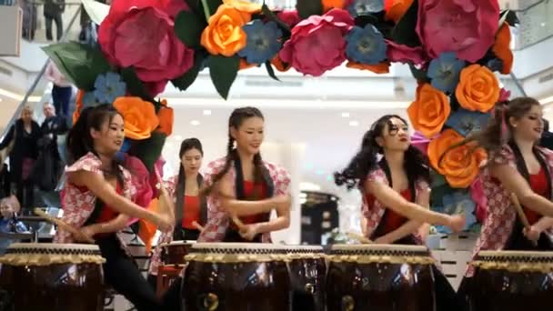 Moscow, Russia - March 4, 2017: group of Japanese Taiko drummers girls perform in "Oceania" shopping center on the at the opening of a new store UNIQLO Unique Clothing Warehouse. — Stock Video