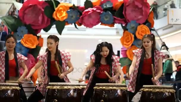 Moskou, Rusland - 4 maart 2017: groep van Japanse Taiko drummers meisjes uitvoert in "Oceanië" shopping center op het slaan bij de opening van een nieuwe Uniqlo unieke kleding magazijn. — Stockvideo