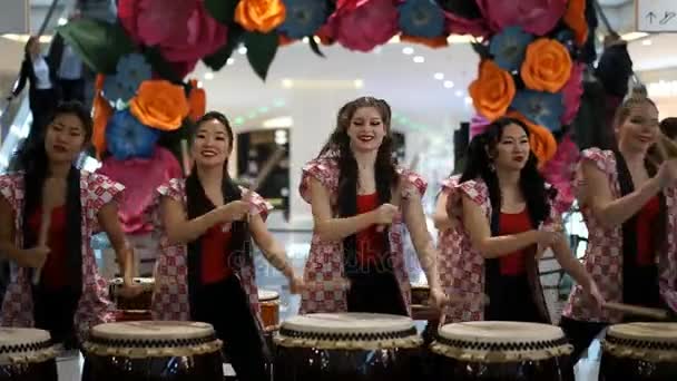 Moskou, Rusland - 4 maart 2017: groep van Japanse Taiko drummers meisjes uitvoert in "Oceanië" shopping center op het slaan bij de opening van een nieuwe Uniqlo unieke kleding magazijn. — Stockvideo