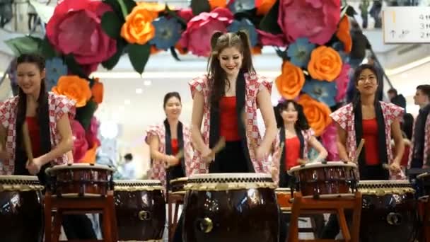 Moskou, Rusland - 4 maart 2017: groep van Japanse Taiko drummers meisjes uitvoert in "Oceanië" shopping center op het slaan bij de opening van een nieuwe Uniqlo unieke kleding magazijn. — Stockvideo