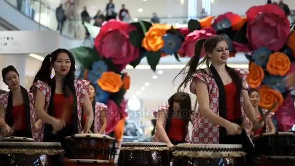 Moskou, Rusland - 4 maart 2017: groep van Japanse Taiko drummers meisjes uitvoert in "Oceanië" shopping center op het slaan bij de opening van een nieuwe Uniqlo unieke kleding magazijn. — Stockvideo