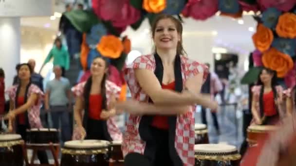 Moscow, Russia - March 4, 2017: group of Japanese Taiko drummers girls perform in "Oceania" shopping center on the at the opening of a new store UNIQLO Unique Clothing Warehouse. Dance with umbrella. — Stock Video