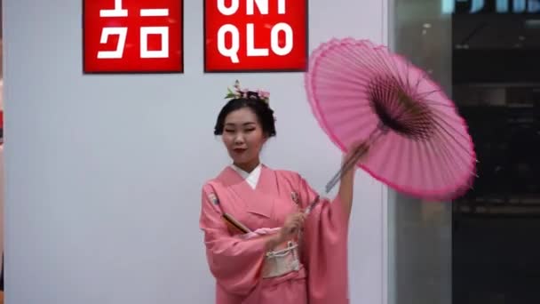 Moskova, Rusya - 5 Şubat 2017: Uniqlo mağaza girişinde şemsiye ile geleneksel Japon kimono geyşa. Performans Rusya'da yeni bir 15 mağaza açılışı için zamanlandı. — Stok video