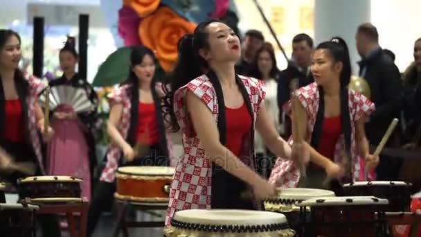 Moskou, Rusland - 5 maart 2017: groep van Japanse Taiko drummers meisjes uitvoert in "Oceanië" shopping center op het slaan bij de opening van een nieuwe Uniqlo unieke kleding magazijn. — Stockvideo