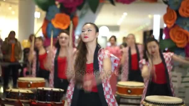 Moskou, Rusland - 5 maart 2017: groep van Japanse Taiko drummers meisjes uitvoert in "Oceanië" shopping center op het slaan bij de opening van een nieuwe Uniqlo unieke kleding magazijn. — Stockvideo