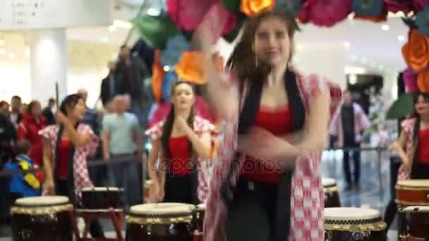 Moscú, Rusia - 4 de marzo de 2017: grupo de bateristas japonesas de Taiko actúan en el centro comercial "Oceanía" en la apertura de una nueva tienda UNIQLO Unique Clothing Warehouse. Baile con paraguas . — Vídeos de Stock