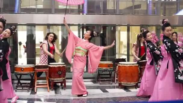 Moscow, Russia - March 24, 2017: group of japanese geishas in traditional japanese kimono dancing in a mall Riviera. The performance dedicated to the new Uniqlo store in Moscow. Dance with parasol. — Stock Video