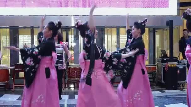 Moscou, Rússia - 24 de março de 2017: grupo de gueixas japonesas no quimono tradicional japonês dançando em um shopping Riviera. O desempenho dedicado à nova loja Uniqlo. Dança com mangas compridas . — Vídeo de Stock
