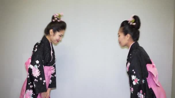 Два гейши в традиционном японском кимоно приветствие — стоковое видео