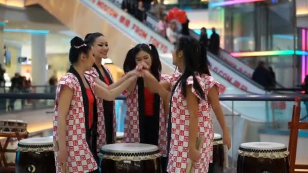 Moskva, Ryssland - 25 mars 2017: Japanska Taiko trummisar flickor i Kalejdoskop köpcentrum vid öppnandet av en ny butik Uniqlo. Flickor skrika Taiko inspiration och plocka upp trumpinnar. — Stockvideo