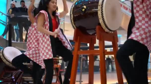 Москва, Російська Федерація - 25 березня 2017: Група японських тайко барабанщики дівчаток виконувати в калейдоскоп торгового центру, на відкритті нового магазину Uniqlo унікальний одяг склад. — стокове відео