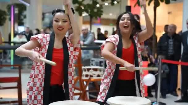 Moscou, Rússia - 25 de março de 2017: grupo de garotas japonesas bateristas Taiko se apresentam no centro comercial Kaleidoscope na abertura de uma nova loja UNIQLO Unique Clothing Warehouse . — Vídeo de Stock