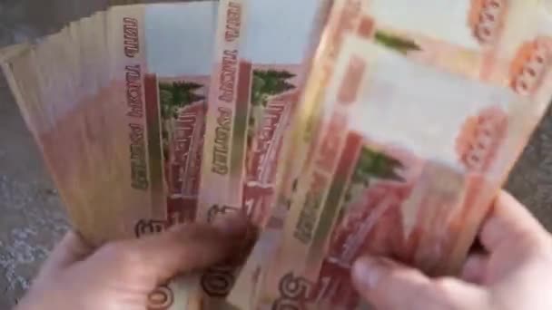 Mãos femininas contar russo 5000 notas de dinheiro e, em seguida, colocar um pacote de notas totalizando 300 mil rublos sobre a mesa — Vídeo de Stock