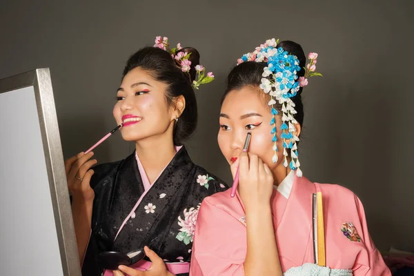 Duas gueixas em quimono japonês tradicional compõem bastidores — Fotografia de Stock