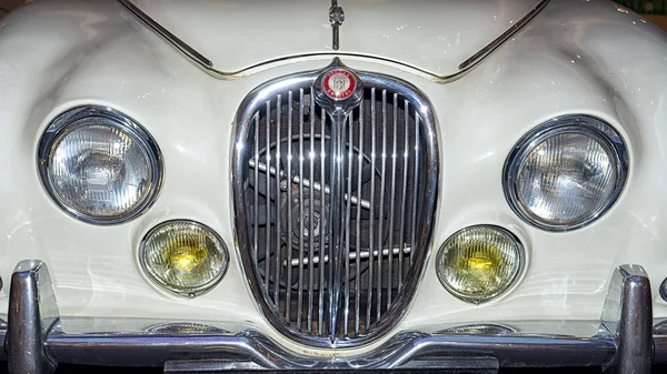 Moscú, Rusia - 02 de abril de 2017: Faros delanteros y rejilla de un Jaguar blanco restaurado tipo S, 3,8 litros, Gran Bretaña 1965, primer plano frontal. exibition coche retro en centro comercial Metropolis . — Foto de Stock