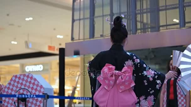 俄罗斯莫斯科-2017 年 3 月 24 日︰ 日本艺妓在跳舞在购物中心里维埃拉的传统日本和服组。致力于新的优衣库存储性能。与歌迷共舞. — 图库视频影像