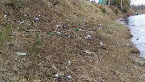 Odpadky na břehu řeky ukazuje znečištění. — Stock video
