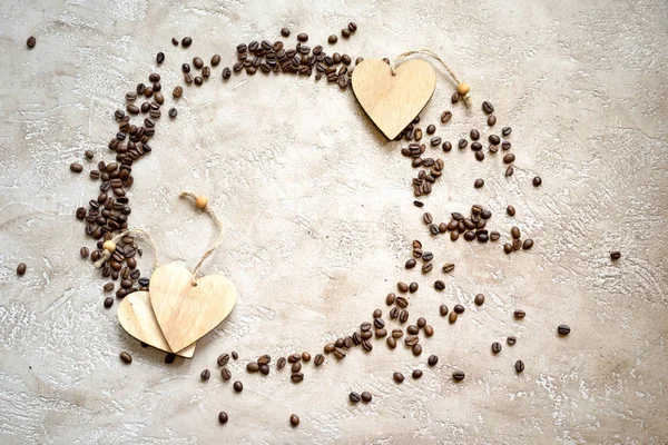 Silhueta de círculo feita de grãos de café com etiquetas de coração de madeira e espaço de cópia, vista superior. Pode ser usado como gráfico de torta sobre o consumo de café . — Fotografia de Stock