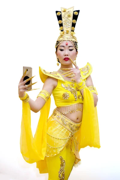 Красивая азиатская женщина в традиционном китайском желтом платье делает селфи изолированы на белом фоне — стоковое фото