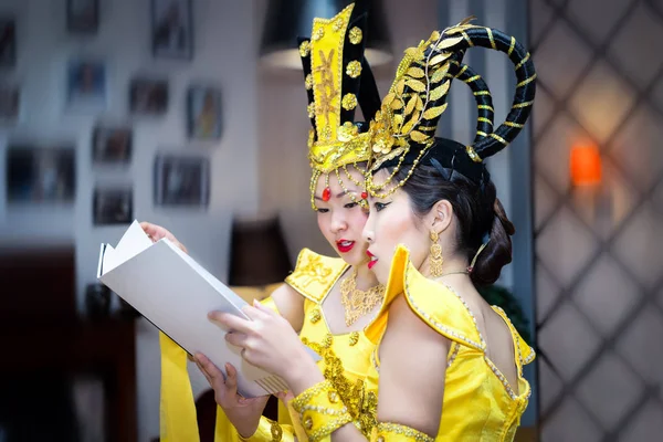 Due attrice asiatica in un giallo tradizionale cinese libretto di lettura costume di scena — Foto Stock