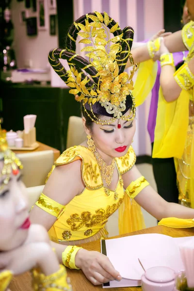 Азиатская актриса в традиционном желтом китайском меню для чтения костюмов в ресторане — стоковое фото
