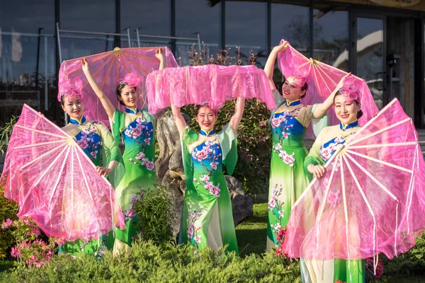 Grupp av fem asiatiska kvinnor skådespelerskor i traditionella kinesiska dräkter med fläktar utomhus — Stockfoto