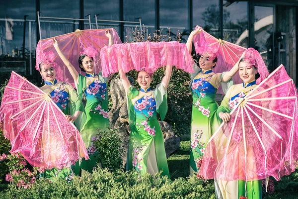 Two beautiful asian girls in traditional chinese blue and green dresses  with umbrella in a form of lotus flowers Stock Photo by ©Elf+11 115631118