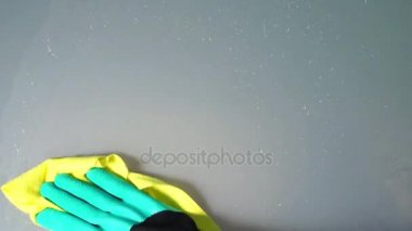 Sarı bez temizlik ile yeşil eldiven kadının elinde buzlu cam ıslak