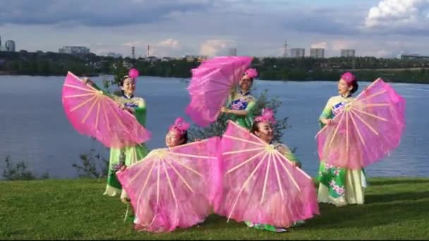 group of five asian women actresses in traditional chinese costumes with fans dancing at the river bank outdoor