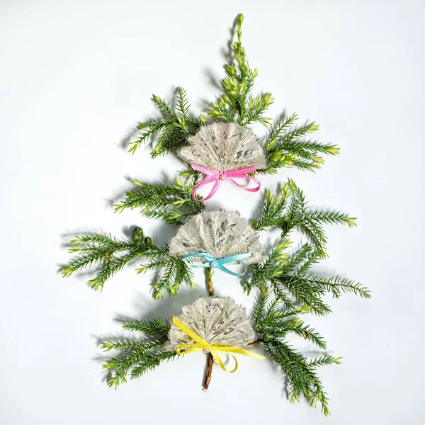 Piatto laici piccolo albero di Natale costituito da rami di abete decorato con tre ventagli, isolato su sfondo bianco. Capodanno e il concetto di Natale di spagnolo, messicano o cinese fan . — Foto Stock