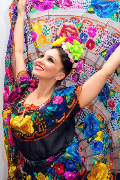 Όμορφη χαμογελαστή Μεξικού γυναίκα στον παραδοσιακό μεξικάνικο φόρεμα τα χέρια ψηλά κρατώντας τη φούστα ως φόντο σαν παγώνι — Φωτογραφία Αρχείου