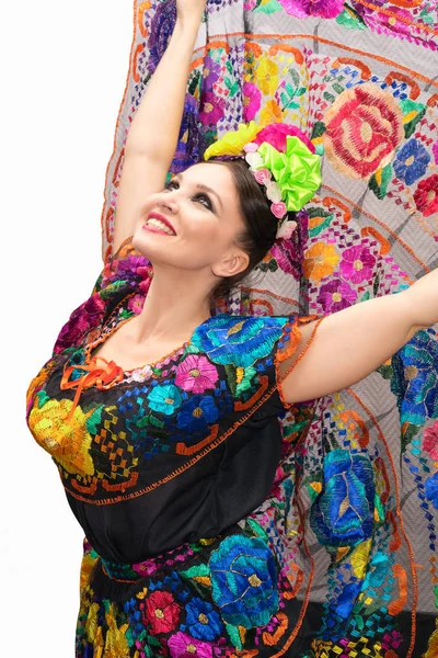 Szép, mosolygós mexikói nő a hagyományos mexikói ruha kezeket fel tartja a szoknya, a háttérben, mint a páva — Stock Fotó