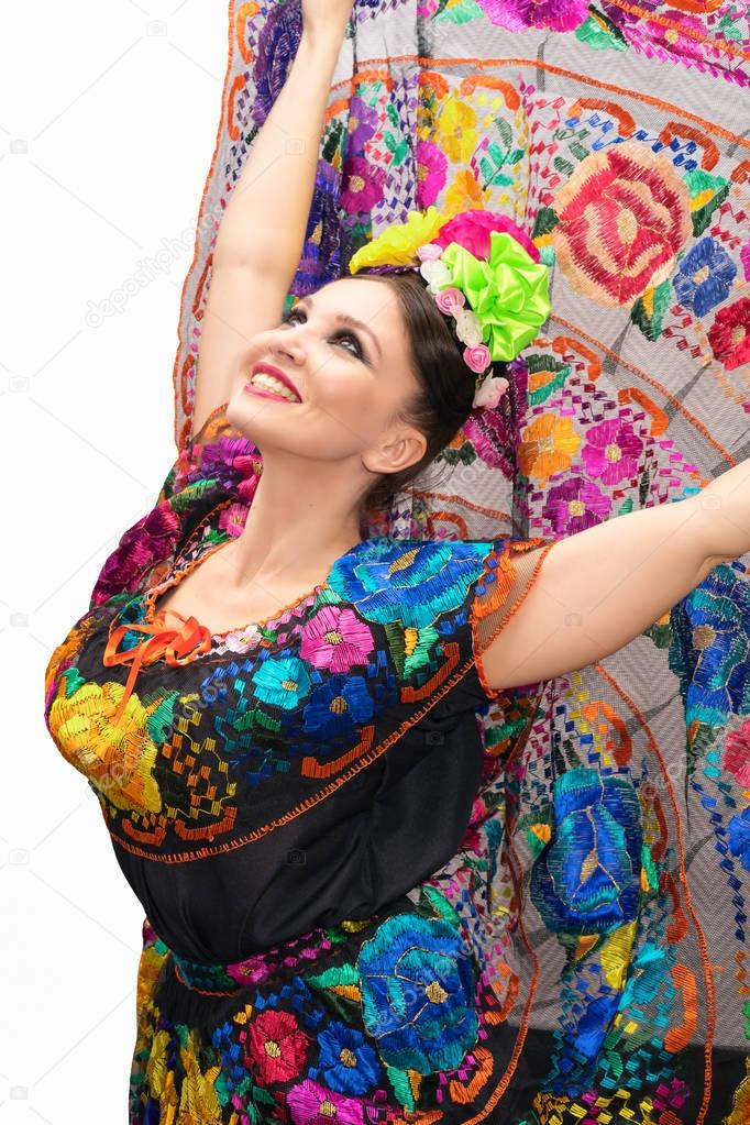 Beautiful smiling mexican woman in traditional mexican dress hands up
