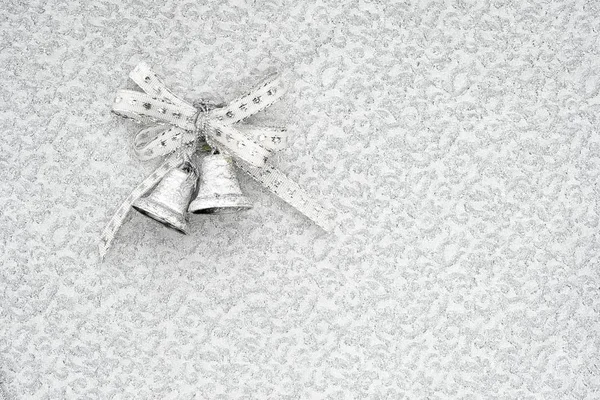 Campanelli in argento jingle su uno sfondo argento con spazio copia. sfondo concettuale di Natale . — Foto Stock