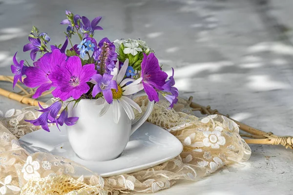 野生花卉花束用蓝色铃铛 chamomiles，忘了我不在副本空间白色茶杯 — 图库照片