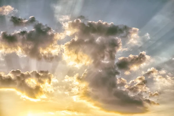 Bunter dramatischer Himmel mit Wolken und Sonnenstrahlen bei Sonnenuntergang. — Stockfoto