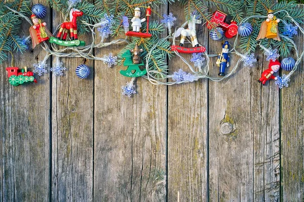 Moldura de borda de natal com ramos de abeto, guirlanda e brinquedos de Natal em uma velha mesa de madeira rústica, vista superior com espaço de cópia para o seu texto — Fotografia de Stock