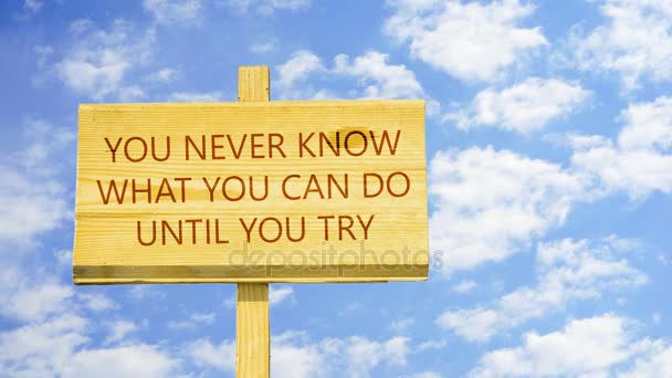 You never know what you can do until you try. Words on a wooden sign against time lapse clouds in the blue sky. — Stockvideo