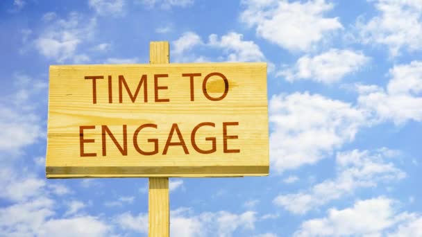 Time to engage. Words on a wooden sign against time lapse clouds in the blue sky. — Stock Video