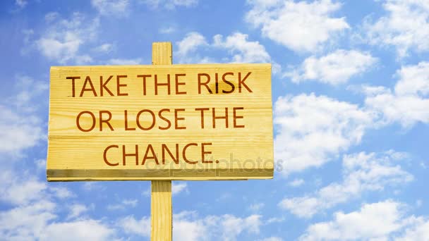 Take the risk or lose the chance. Words on a wooden sign against time lapse clouds in the blue sky. — Stock Video