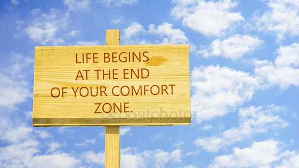 Cita motivacional para crear futuro. La vida comienza al final de tu zona de confort. Palabras en un letrero de madera contra nubes de lapso de tiempo en el cielo azul . — Vídeos de Stock