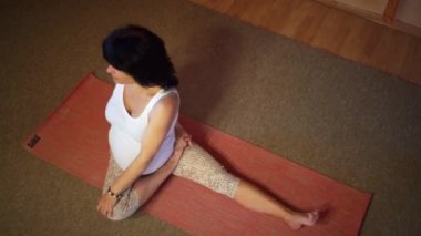 Yoga egzersiz yaparak asana oturan 40 haftalık hamile orta yaşlı beyaz kadın. Üstten Görünüm.